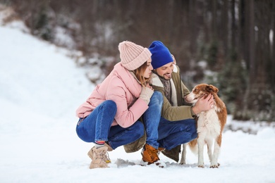 Photo of Cute couple with dog outdoors. Winter vacation
