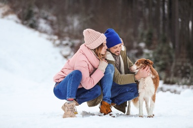 Cute couple with dog outdoors. Winter vacation