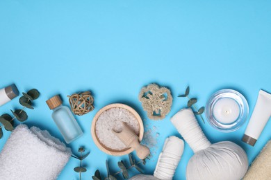 Flat lay composition with spa products and eucalyptus branches on light blue background. Space for text