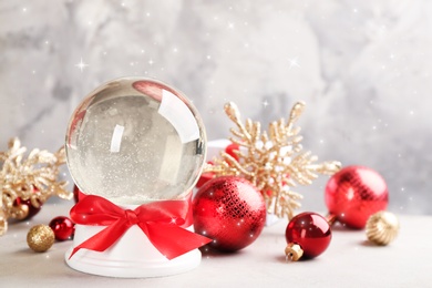 Image of Beautiful snow globe and Christmas balls on light table