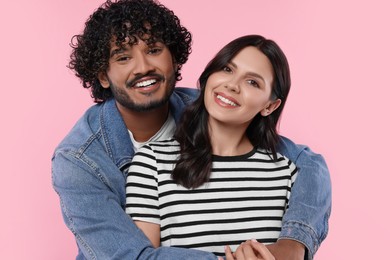 International dating. Happy couple hugging on pink background
