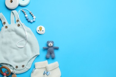 Flat lay composition with cute baby stuff on light blue background, space for text