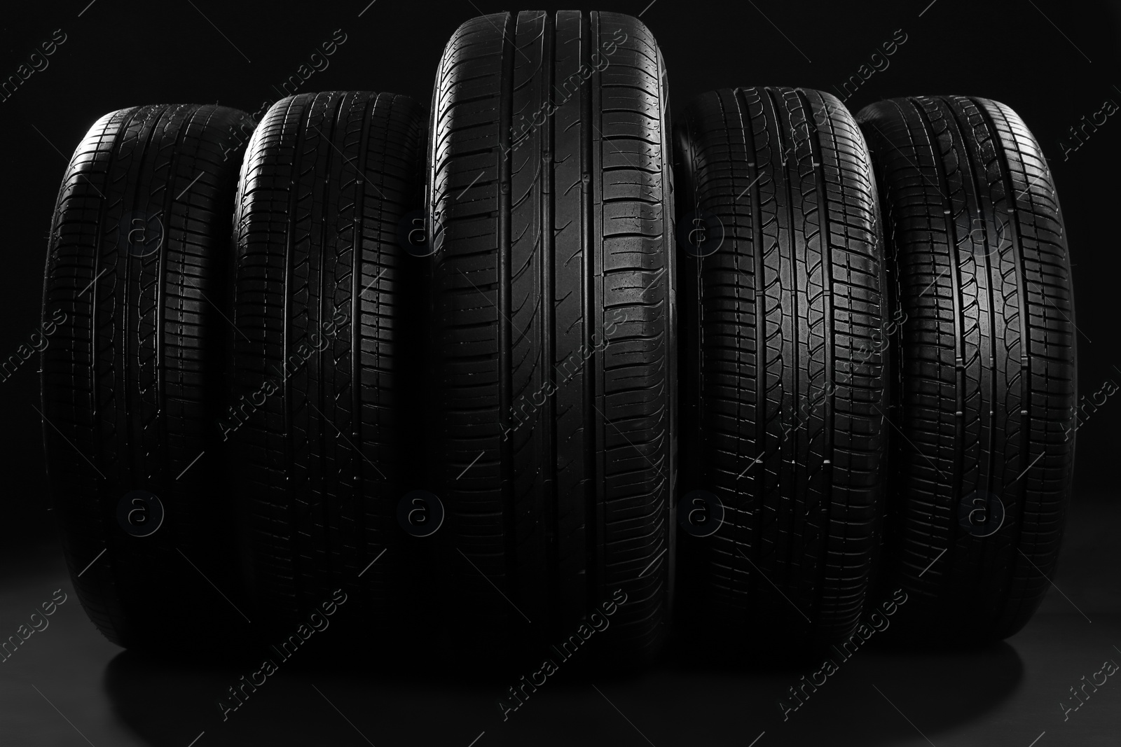 Photo of New car tires on black background