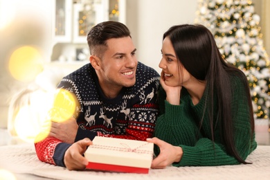 Happy couple with Christmas gift box at home