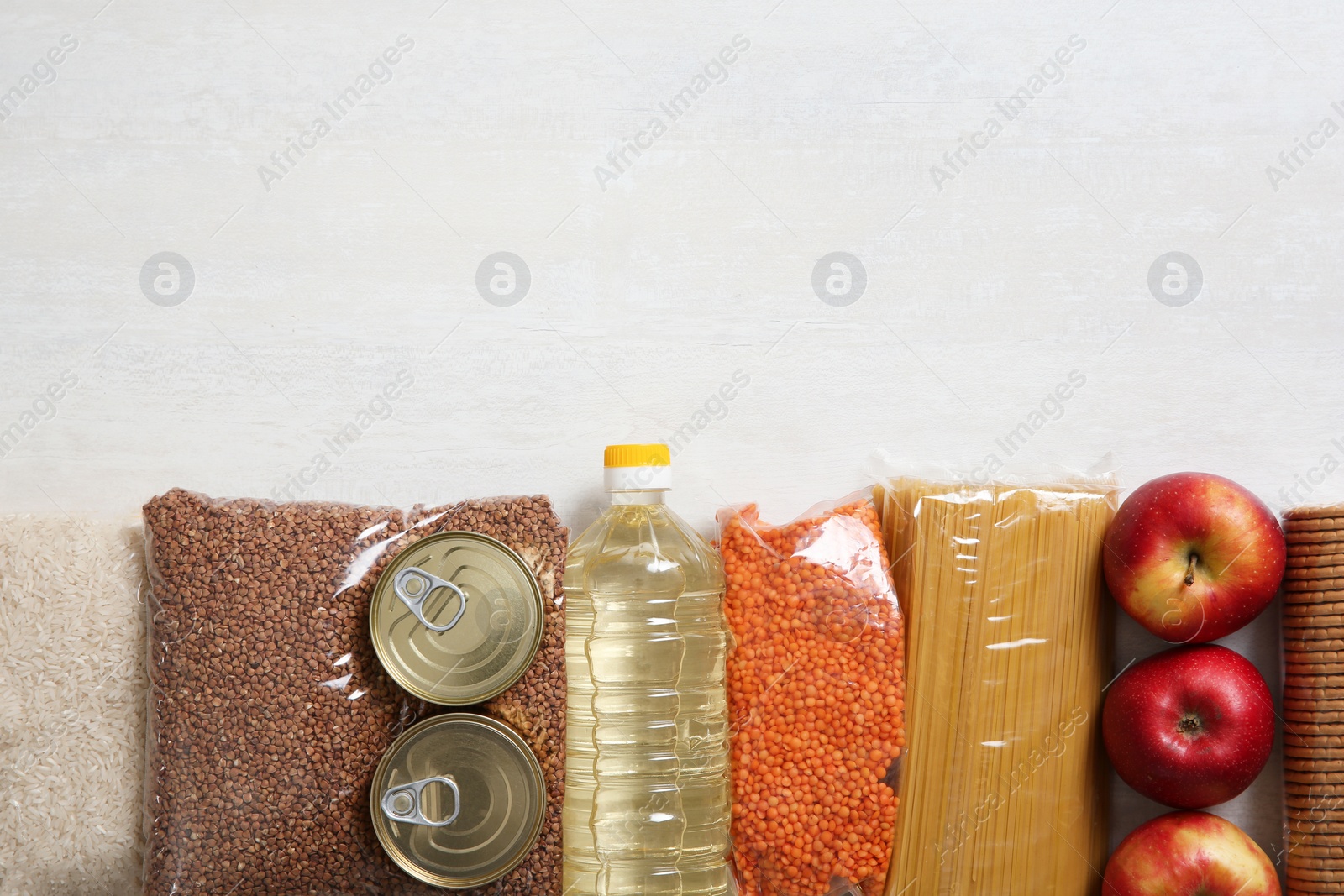 Photo of Many different products and space for text on white wooden background, flat lay. Food donation