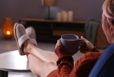 Photo of Woman with cup of aromatic coffee relaxing at home, closeup. Space for text