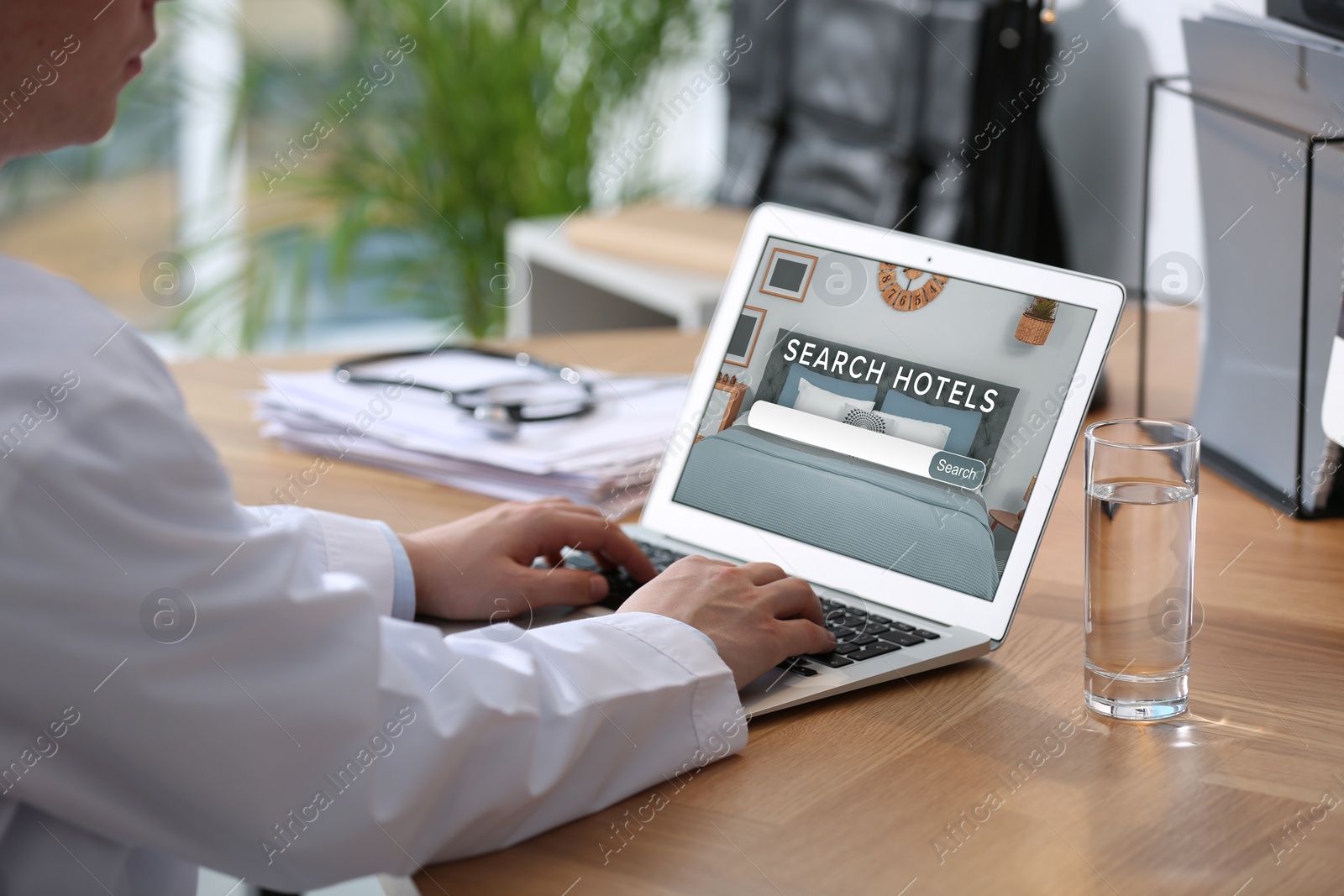 Image of Doctor searching hotel using laptop at table, closeup. Booking online service