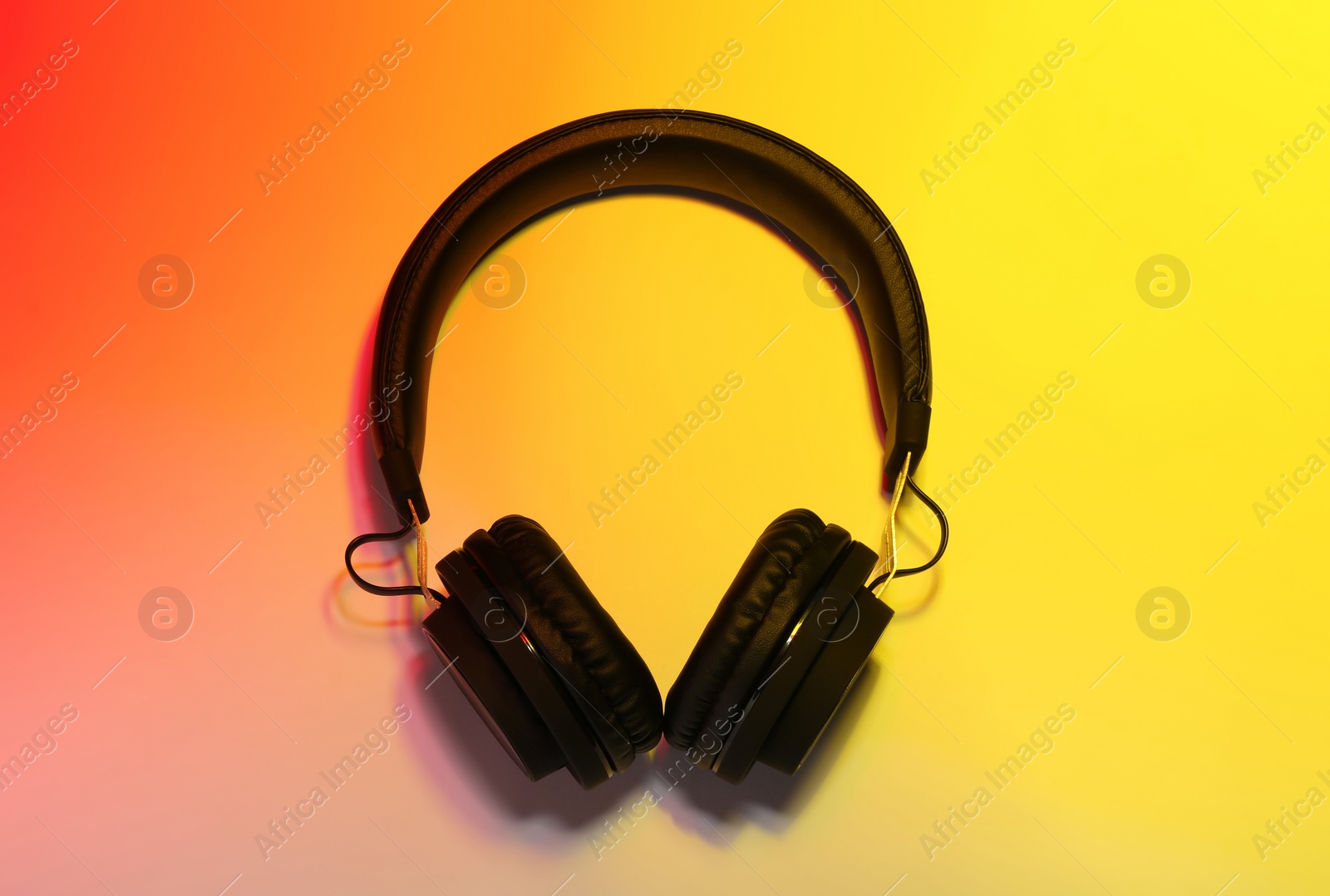 Photo of Stylish headphones on color background, top view