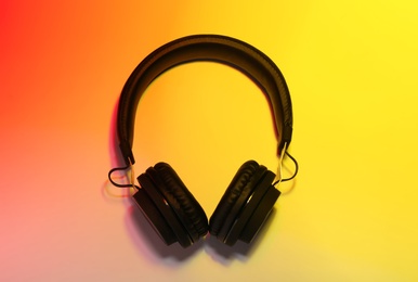 Photo of Stylish headphones on color background, top view