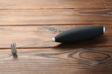 Photo of Black milk frother wand on wooden table