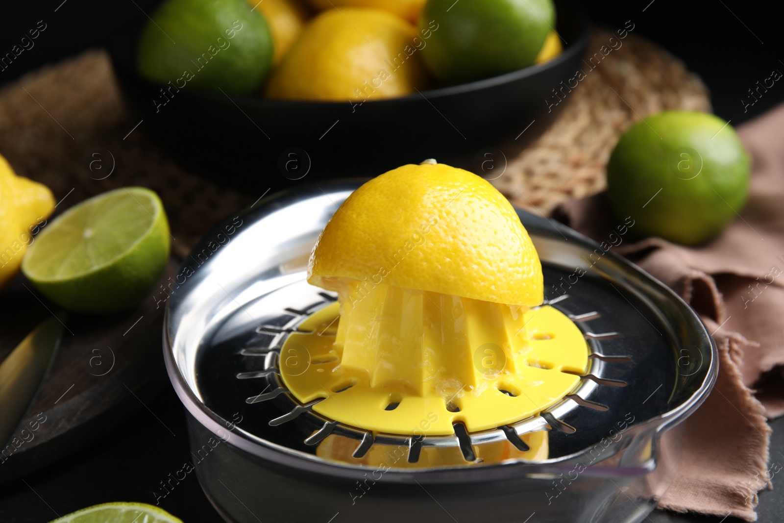 Photo of Squeezer, fresh lemons and limes on table, closeup