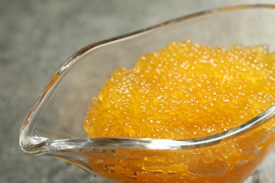 Photo of Fresh pike caviar in gravy boat on table, closeup