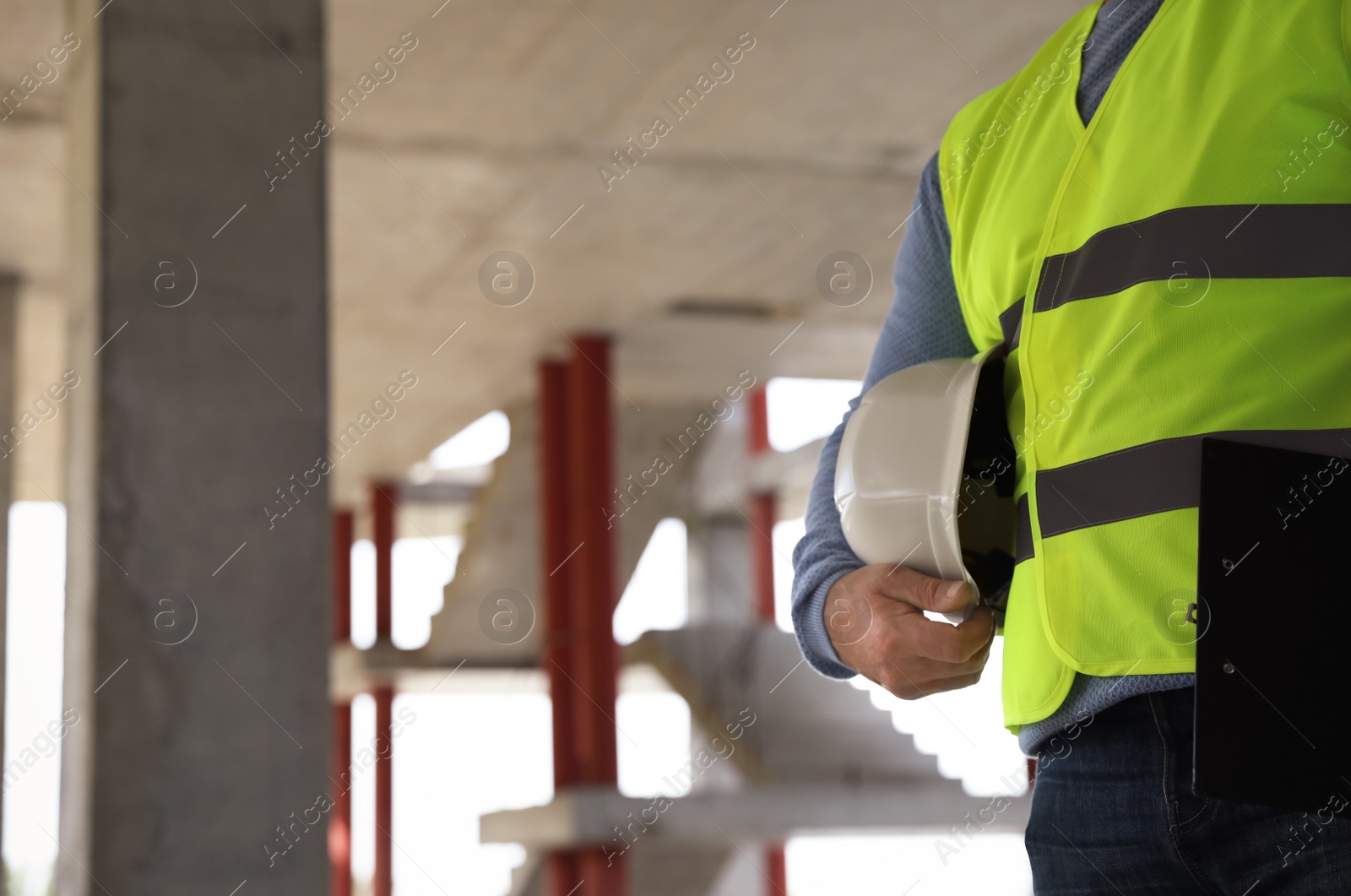 Photo of Professional builder with safety equipment at construction site, closeup. Space for text