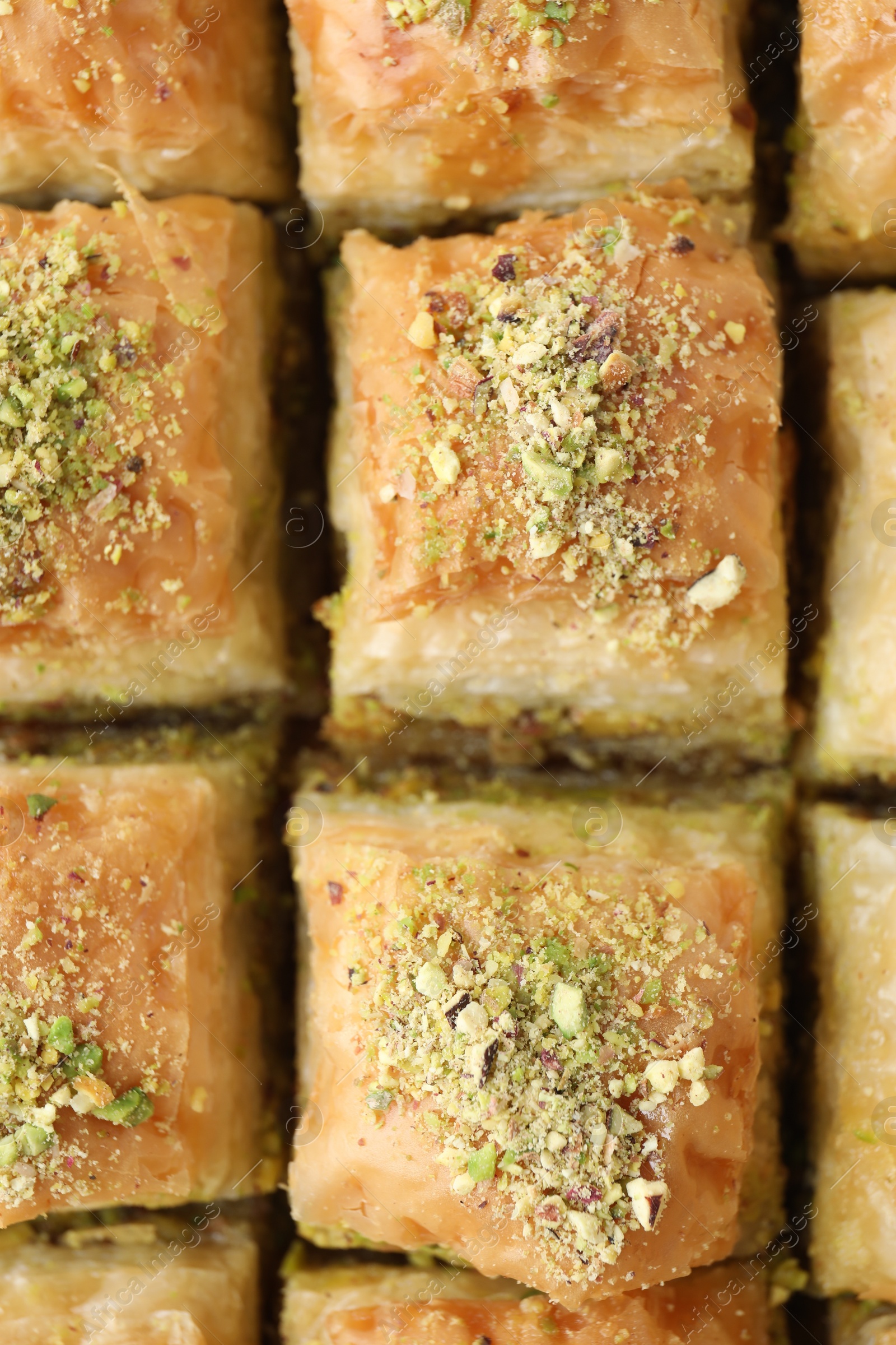 Photo of Delicious fresh baklava with chopped nuts as background, top view. Eastern sweets