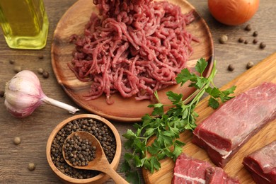 Beef, garlic, oil, parsley and peppercorns on wooden table, closeup