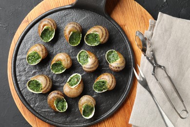 Delicious cooked snails served on grey textured table, flat lay