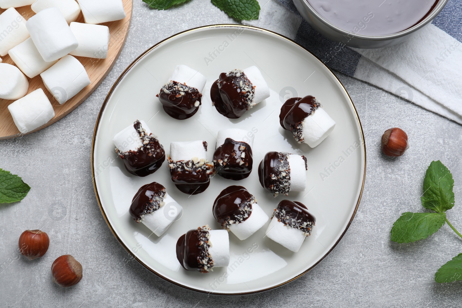 Photo of Delicious marshmallows covered with chocolate and on light table, flat lay