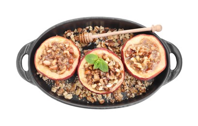 Photo of Tasty baked apples with nuts, honey and mint in baking dish isolated on white, top view