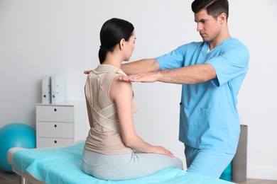 Orthopedist examining woman in clinic. Scoliosis treatment