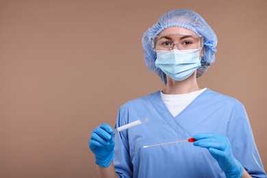 Laboratory testing. Doctor with cotton swab and tube on light brown background, space for text