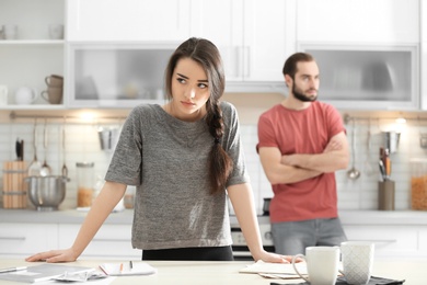 Photo of Young couple ignoring each other after having argument in kitchen