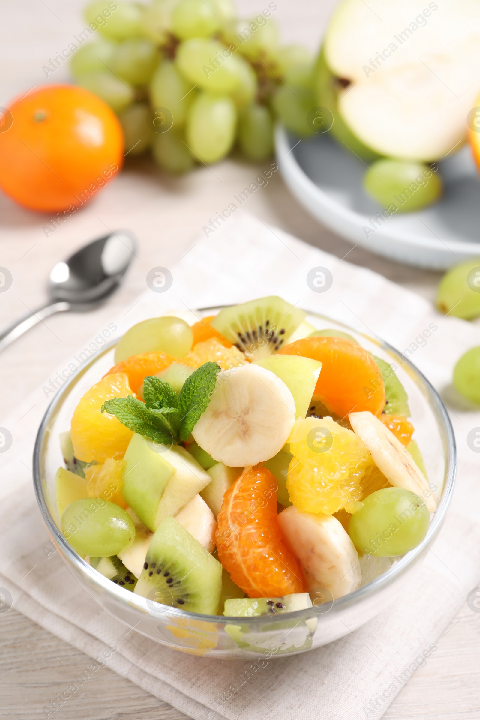 Photo of Delicious fresh fruit salad in bowl on table