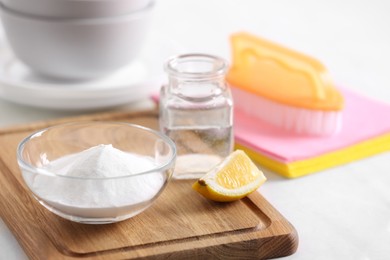 Photo of Baking soda, lemon and vinegar on white table. Eco friendly detergents