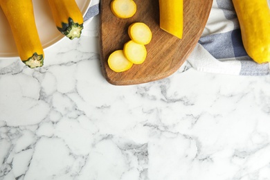 Photo of Flat lay composition with fresh ripe yellow zucchinis on marble table, space for text