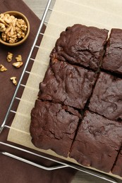 Delicious freshly baked brownies and walnuts on wooden table, flat lay