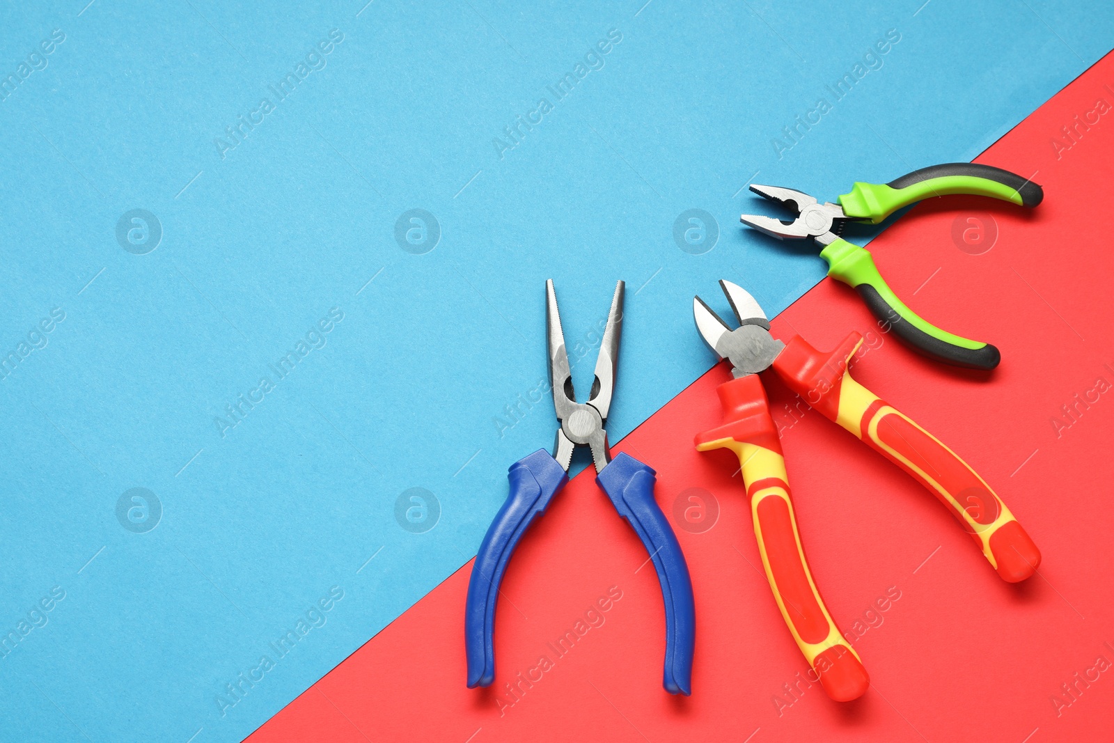 Photo of Different pliers on color background, flat lay. Space for text