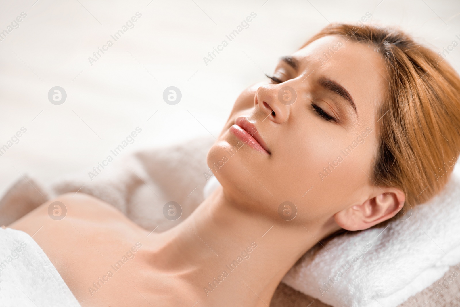 Photo of Beautiful woman with silky skin after face mask relaxing in spa salon