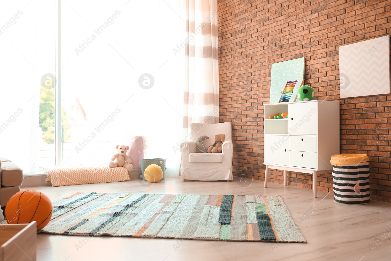 Photo of Stylish child room interior with comfortable armchair