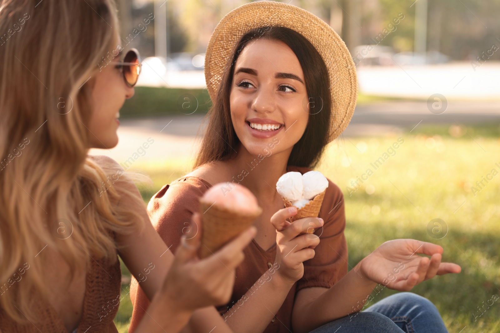 Photo of Young women with ice cream spending time together outdoors