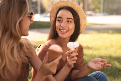 Photo of Young women with ice cream spending time together outdoors