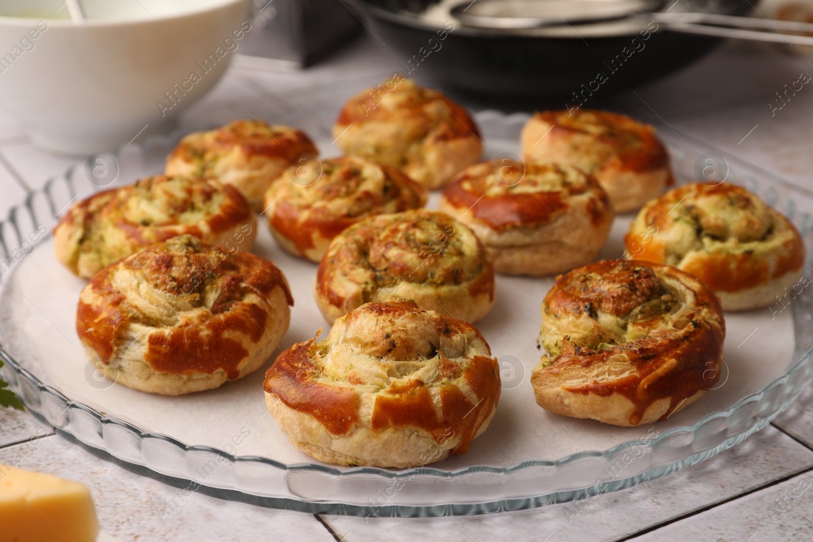 Photo of Fresh delicious puff pastry with tasty filling on white tiled surface, closeup