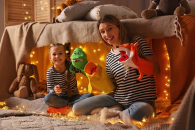 Photo of Mother and her daughter playing with toys in play tent at home