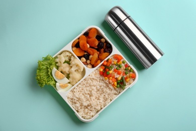 Photo of Thermos and lunch box with food on turquoise background, flat lay