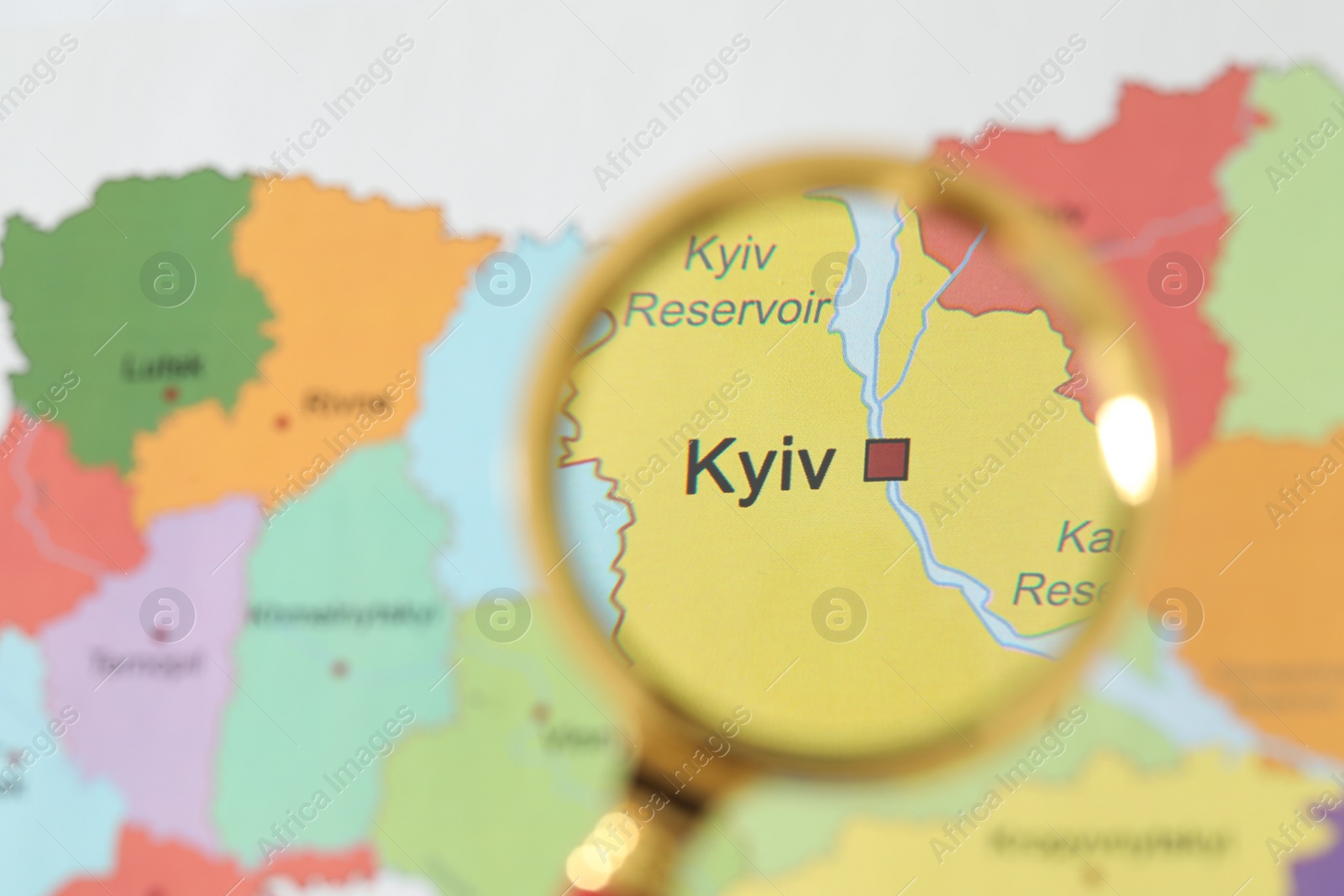 Photo of Golden magnifying glass above Kyiv region on map of Ukraine, closeup