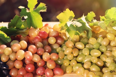 Photo of Fresh ripe juicy grapes on table against blurred background