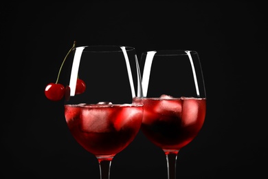 Photo of Delicious cherry wine with ripe juicy berries on black background, closeup