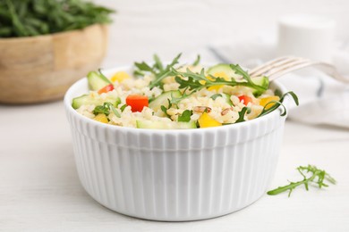 Photo of Cooked bulgur with vegetables in bowl on white wooden table, closeup