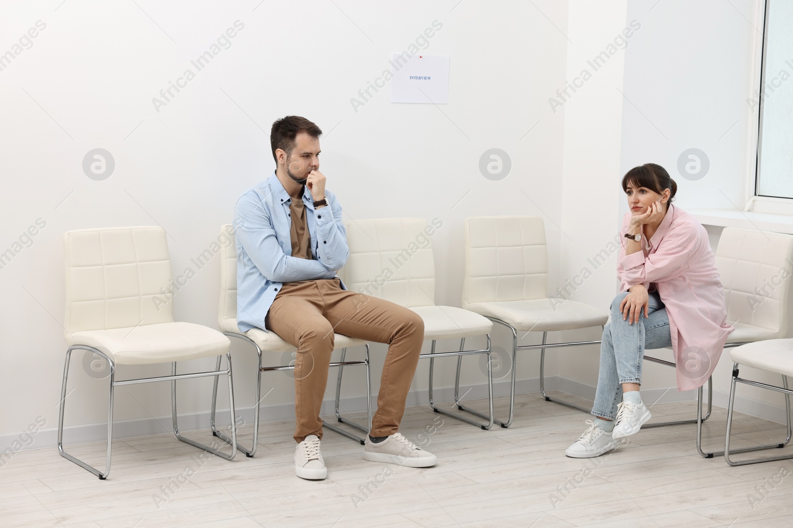 Photo of Man and woman waiting for job interview indoors