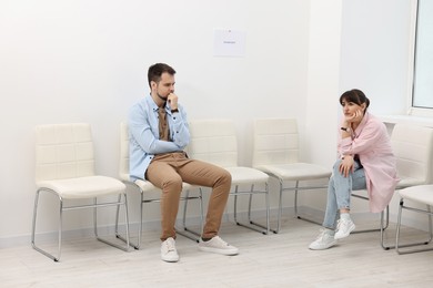 Man and woman waiting for job interview indoors