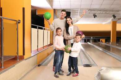 Photo of Happy family spending time together in bowling club