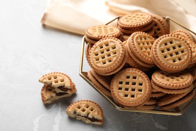 Photo of Tasty sandwich cookies with cream on grey table, closeup. Space for text