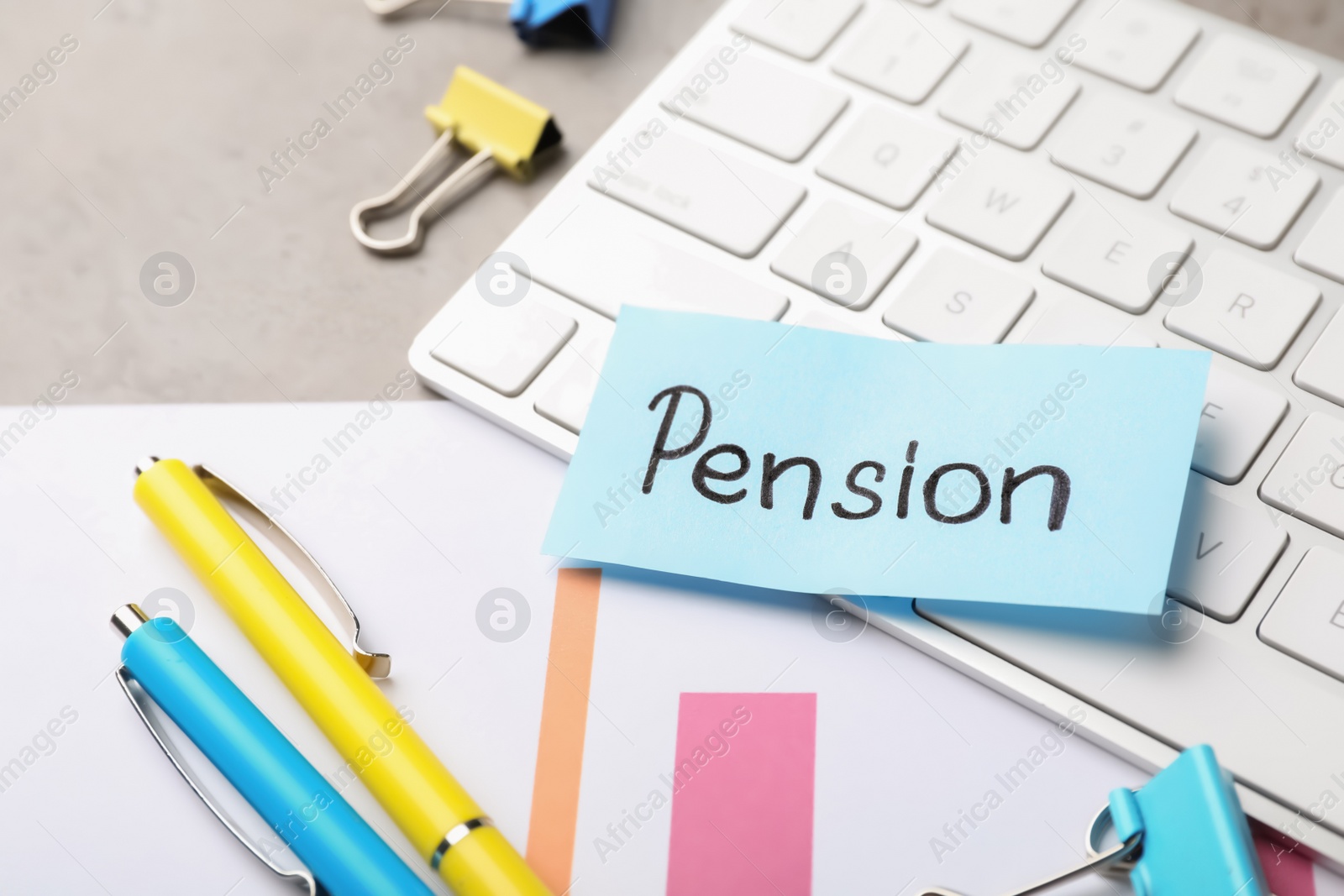 Photo of Keyboard, stationery and paper with word PENSION on table