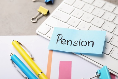 Keyboard, stationery and paper with word PENSION on table