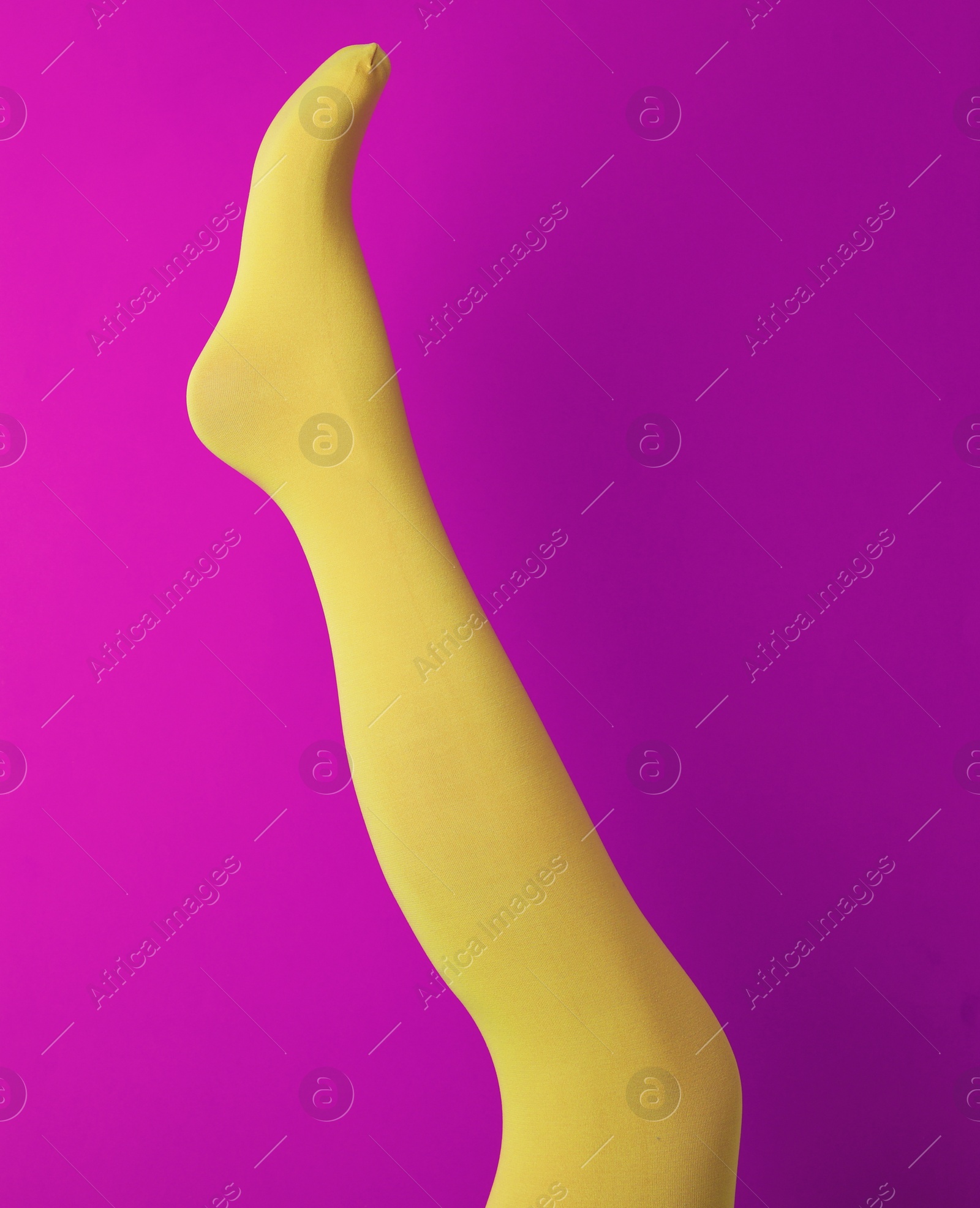 Photo of Leg mannequin in yellow tights on purple background