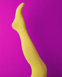 Leg mannequin in yellow tights on purple background