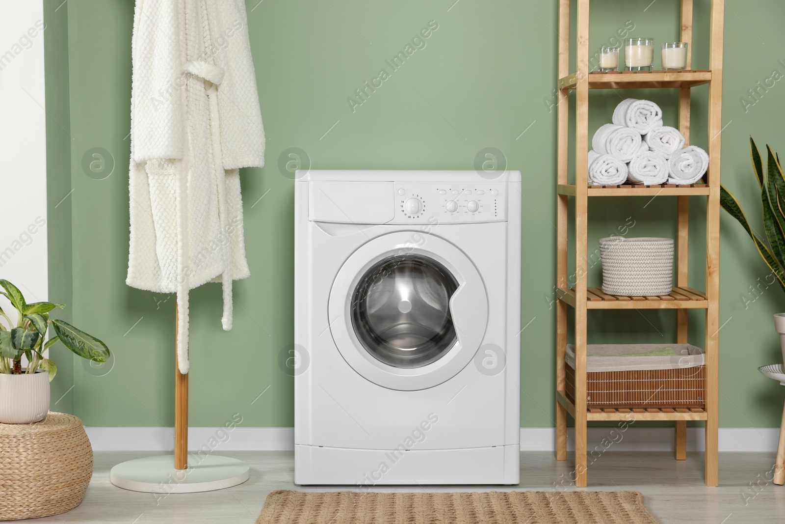 Photo of Stylish laundry room with washing machine. Interior design